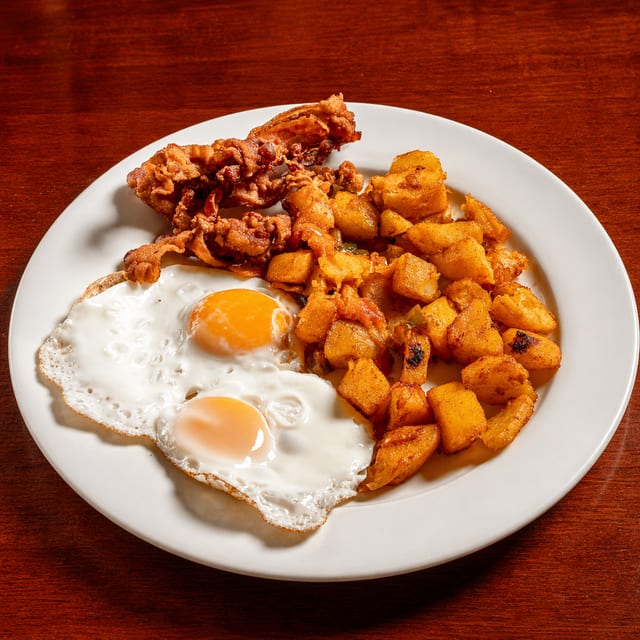 Dos Huevos Cualquier Estilo Servido Con Jamón O Chorizo Espanol O Tocino.