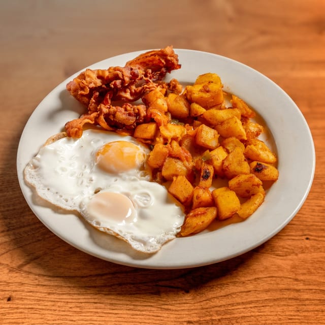 Dos Huevos Cualquier Estilo Servido Con Jamón O Chorizo Espanol O Tocino.